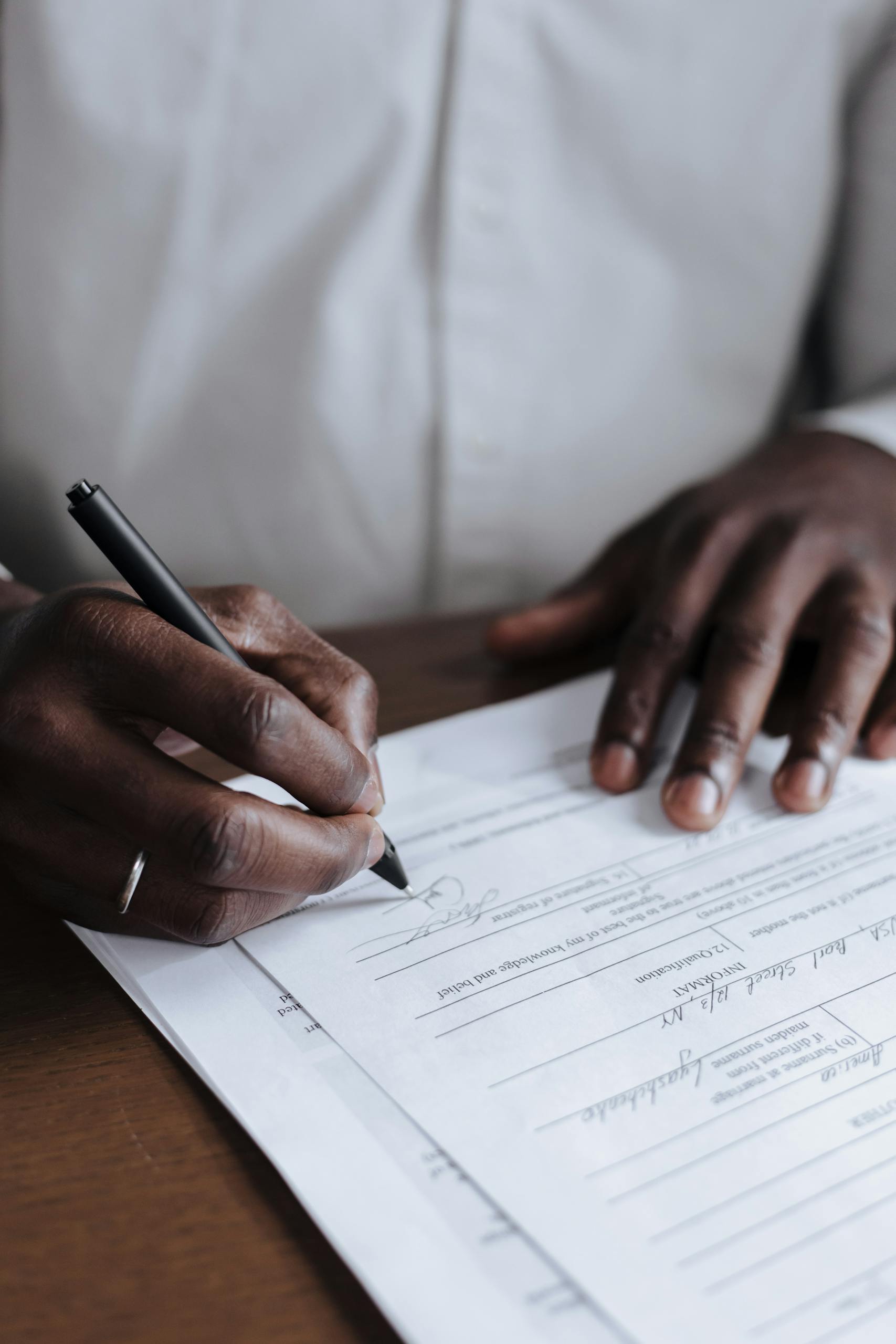 Close-up of a man signing legal documents at home, emphasizing responsibility.